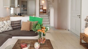 A living room with a wooden coffee table, a sofa, and a kitchen area in the background.