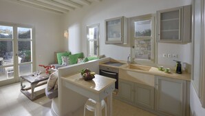 A kitchen with a built-in oven, a sink, and a window overlooking a garden.