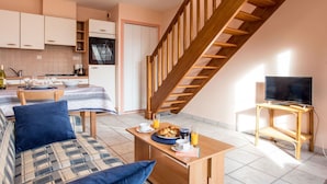 Un appartamento moderno con cucina, zona pranzo e soggiorno.
