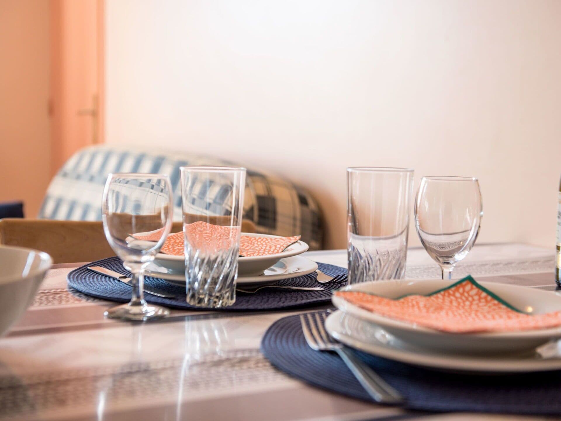 A dining table set with plates, glasses, and cutlery.