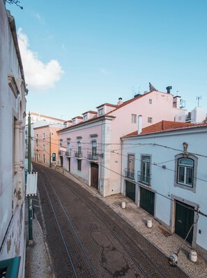 Uma rua ladeada por edifícios, com uma linha férrea no meio.