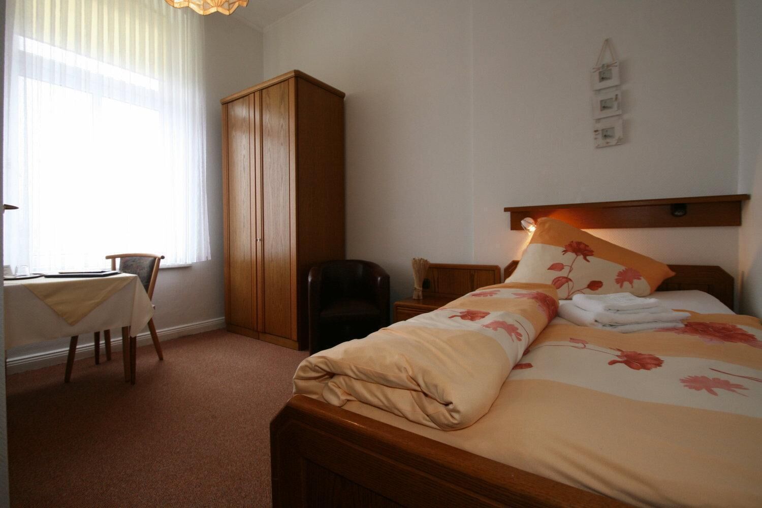 Una habitación de hotel con cama, escritorio y armario.