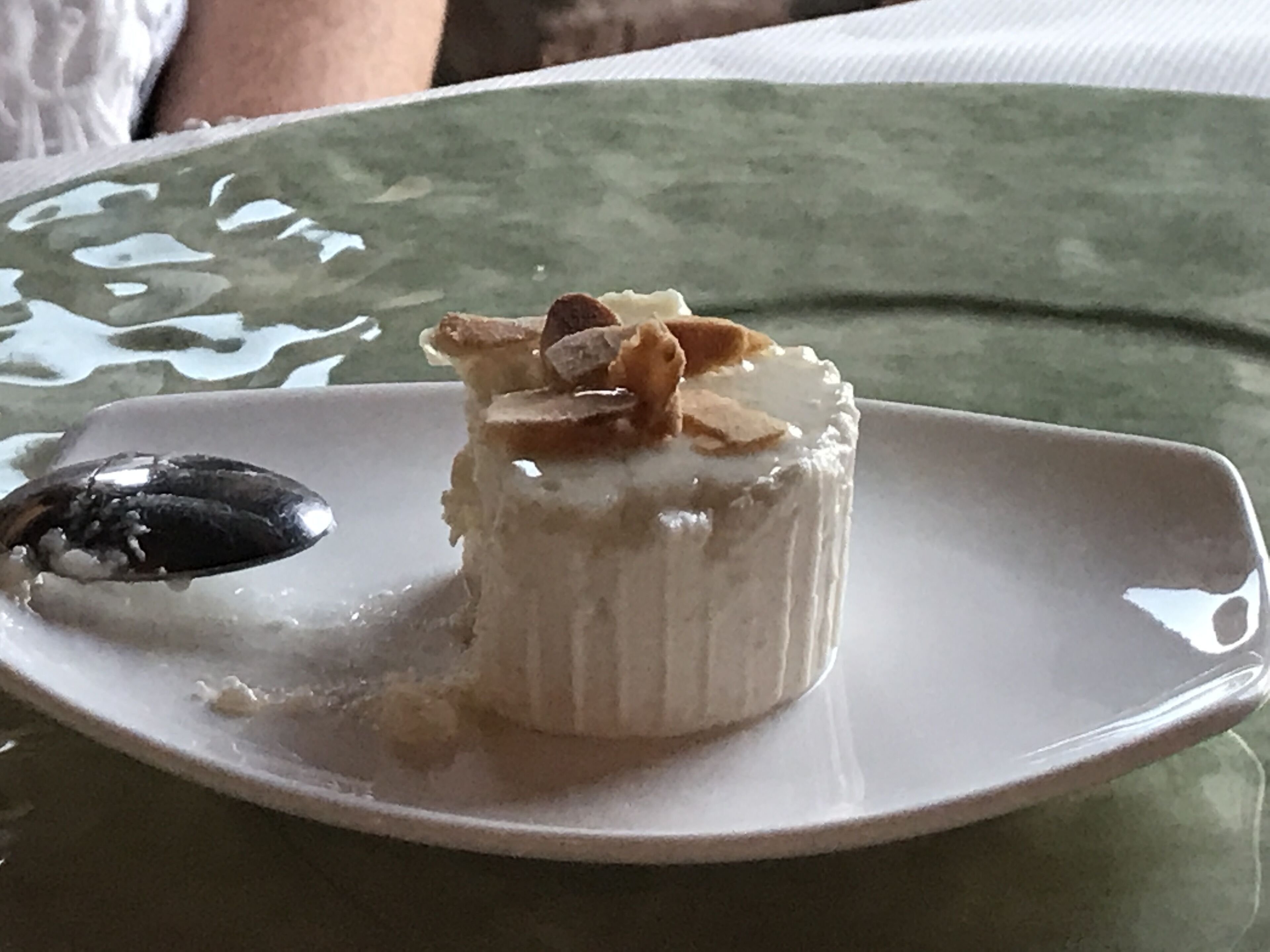 A dessert on a white plate with a green tablecloth.
