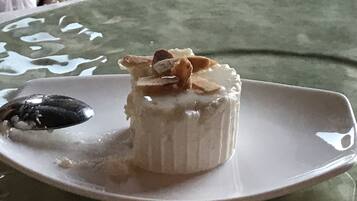 A dessert on a white plate with a green tablecloth.