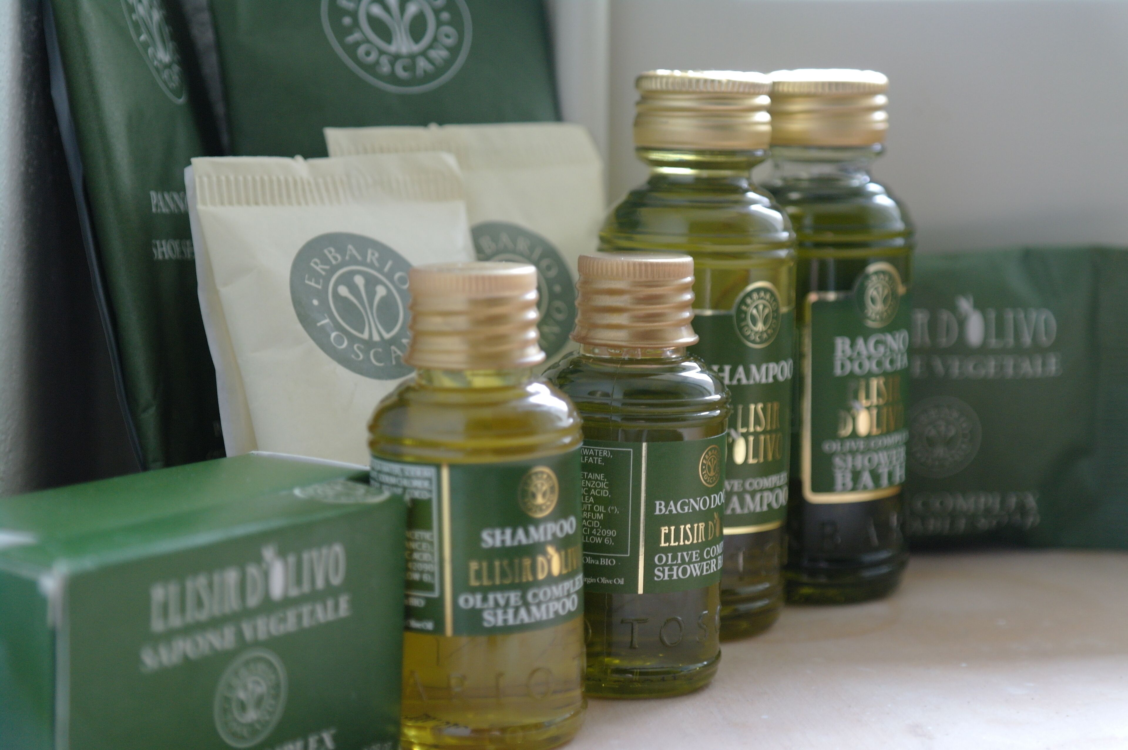 A display of Elisir D'Olivo olive oil products, including shampoo and shower gel.