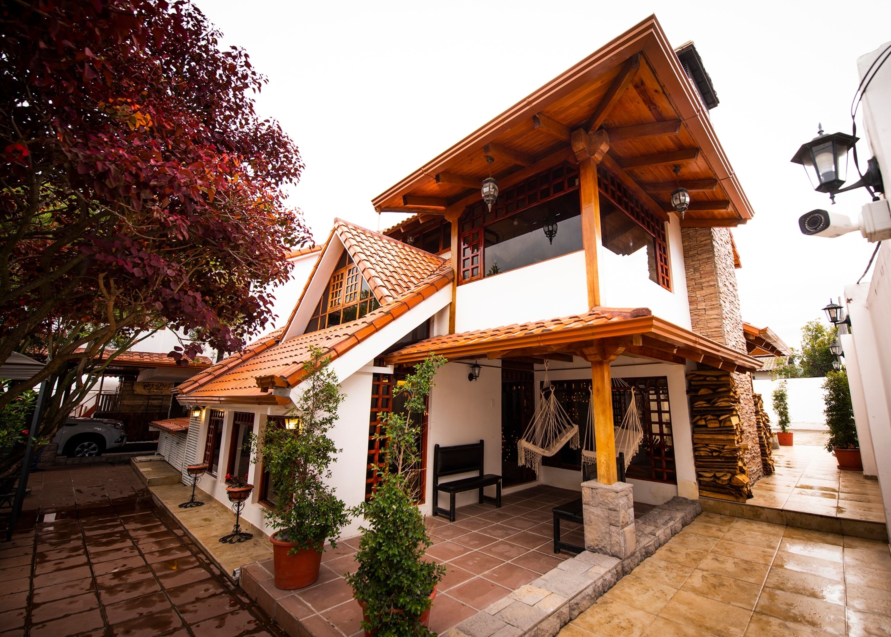 Une maison à deux étages, avec un toit en tuiles, des poutres en bois et un balcon.