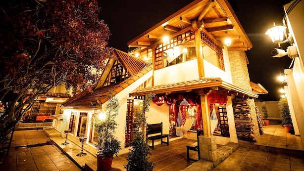 A two-story building with a balcony, wooden beams, and a tiled roof. - Hostal Dulce Hogar (Latacunga)