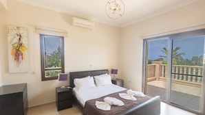 A hotel room with a bed, a desk, a chair, a window, and a balcony. - Villa Jorja, Fabulous and luxurious 7BDR Villa, Close to Fig tree Bay Beach (Protaras)