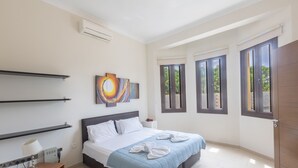 A modern bedroom with a bed, bedside tables, artwork, and large windows. - Villa Jorja, Fabulous and luxurious 7BDR Villa, Close to Fig tree Bay Beach (Protaras)