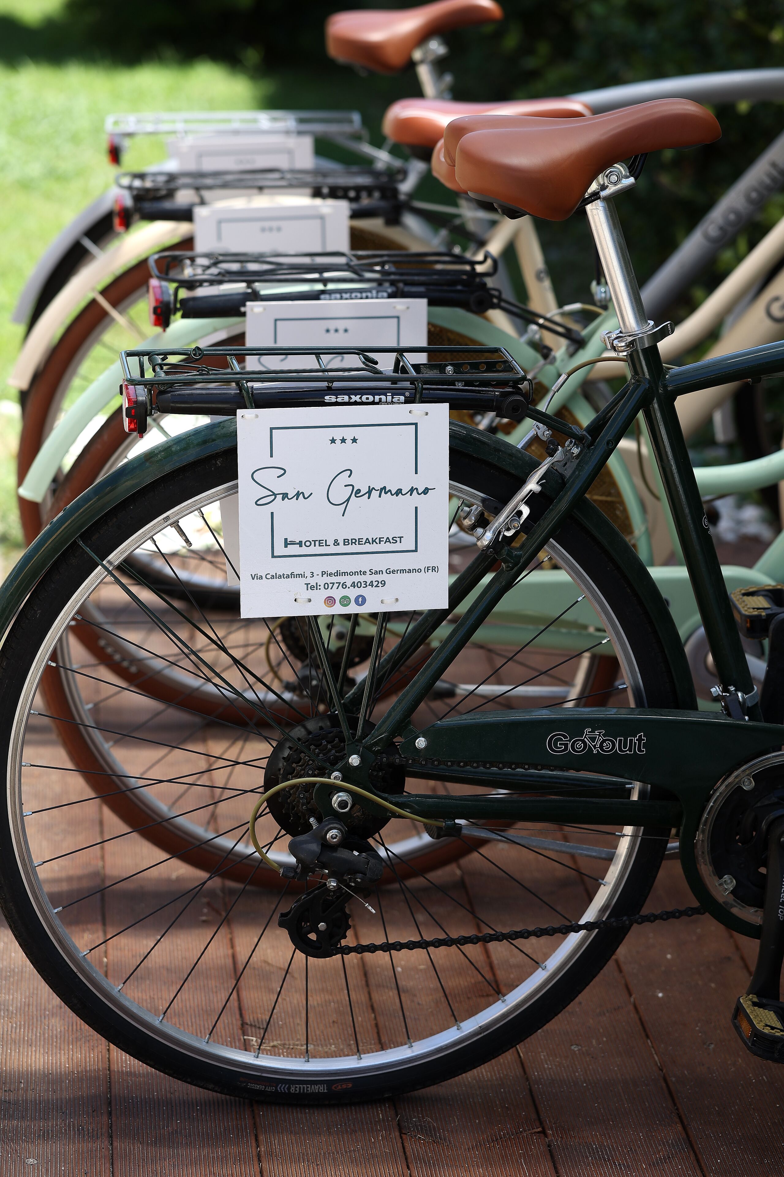 Una bicicleta con un cartel que indica que es para uso de huéspedes y desayuno, ubicada en una terraza de madera.