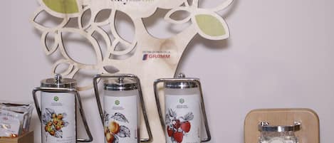 A display of honey dispensers with labels, a wooden tree-shaped sign, and a wooden stand with a jar.