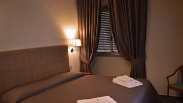 Camera tripla | Una cassaforte in camera, una scrivania, tende oscuranti