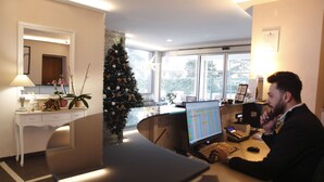 Una oficina moderna con un escritorio, computadora y un árbol de Navidad.