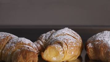 Three croissants dusted with powdered sugar.