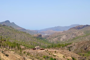 Un paysage montagneux isolé, avec un petit bâtiment rustique situé dans la vallée.