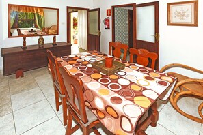 Une salle à manger avec une grande table, des chaises et un vase décoratif.