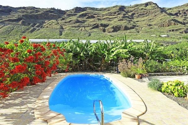 Une piscine avec vue sur les montagnes et un plan d’eau en arrière-plan.