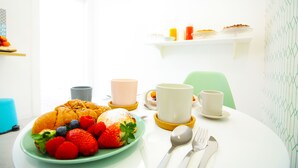A breakfast table with a plate of fruit, pastries, and two cups. - Le Quinte del Bellini (Naples)