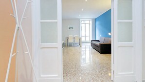 An open doorway leading to a living area with a sofa and a dining table. - Casa dell'Artista Roma (Rome)