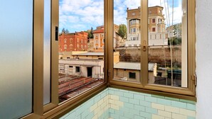 A room with a large window offering a view of buildings and a clear sky. - Casa dell'Artista Roma (Rome)