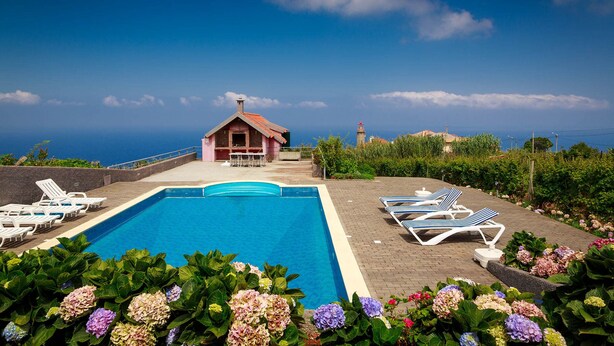 A swimming pool with lounge chairs and a small building with a red roof. - A Casa do Lagar In a peaceful and solitary area with a pleasant climate all year (São Jorge)