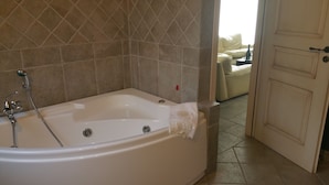 A bathroom with a bathtub, shower, and tiled walls.