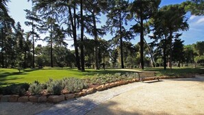 A paved pathway leading through a park with a grassy area and trees. - Casa Camilla, new welcoming structure to feel at home (Roma)