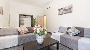 A modern living room with two sofas, a coffee table, and a vase with flowers. - Casa Camilla, new welcoming structure to feel at home (Roma)