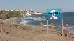 Rantaopastekyltti, jossa lukee: Playa Naturista, nudistiranta.
