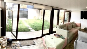 A living room with a sofa, a television, and a kitchen area visible through an open door. - Adonay's house, it's also your house! (Huétor Vega)