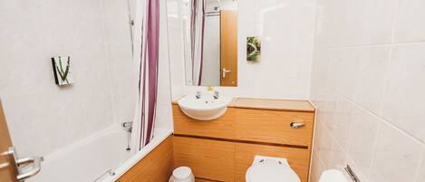 A modern bathroom with a bathtub, a sink, a toilet, and a shower.