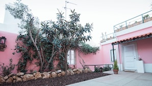 A pink building with a stone wall and a tree in the foreground. - Alfama Dream Apartments 1 (Lisboa)