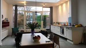 A modern kitchen with a dining area, large windows, and a skylight. - 300 meters from the sunniest coast of the Netherlands (Vlissingen)