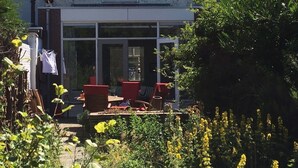 A house with a large front porch, a chimney, and a garden with yellow flowers. - 300 meters from the sunniest coast of the Netherlands (Vlissingen)