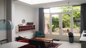 A modern living room with a skylight, a dining area, and a view of a garden through large sliding doors. - 300 meters from the sunniest coast of the Netherlands (Vlissingen)