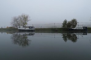 Two boats on a calm body of water with reflections of trees and a clear sky. - Pension Haus am Walde (Brodenbach)