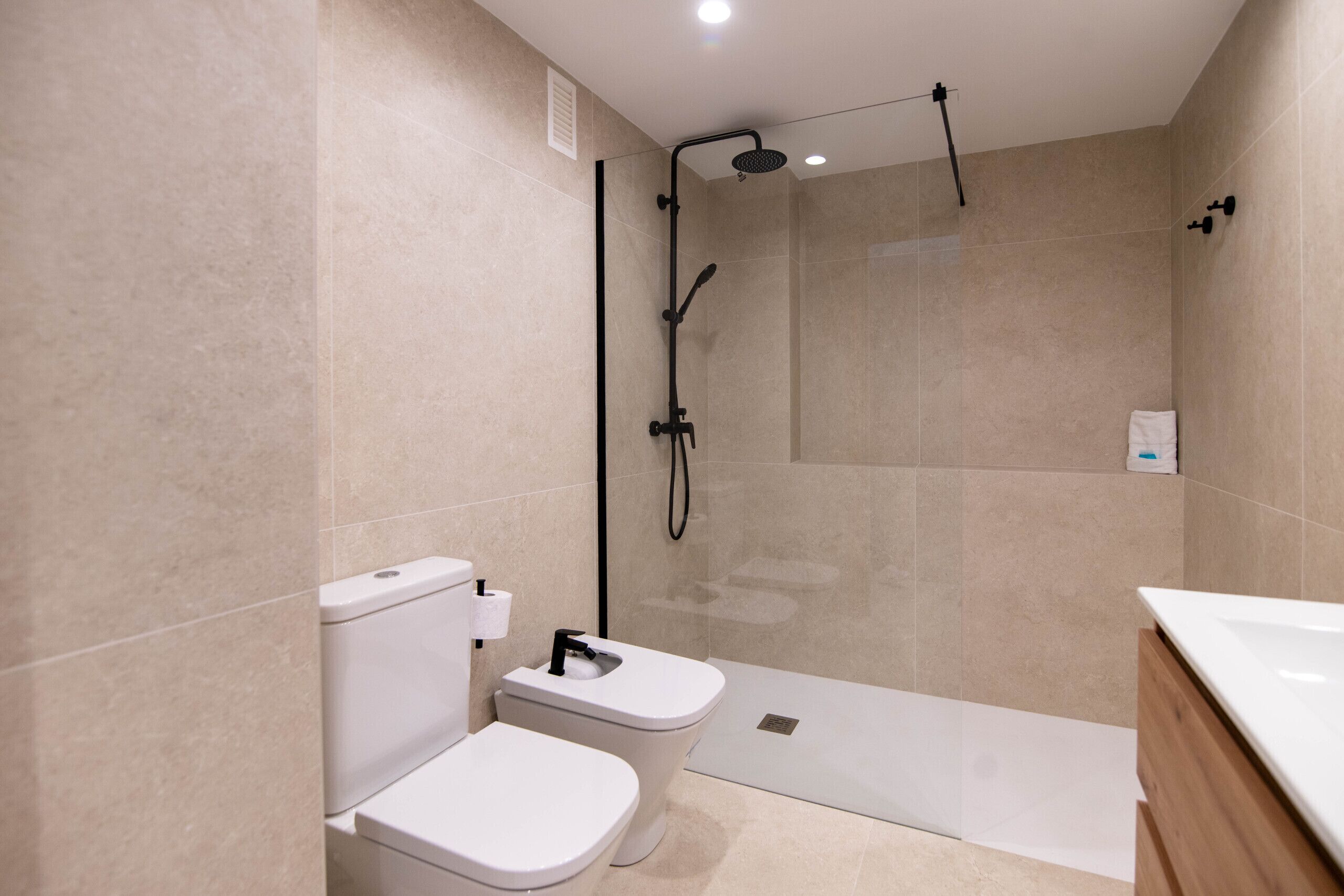 Ein modernes Badezimmer mit Dusche, Toilette und Waschbecken.