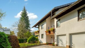 Un bâtiment à deux étages avec une allée en gravier, une enseigne portant le nom « Selina » et un balcon agrémenté de plantes en pot.
