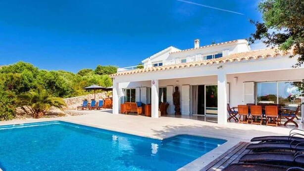Een moderne villa met zwembad, buitenzitplaatsen en een overdekt patio.