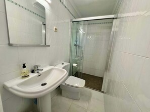 A bathroom with a white sink, toilet, and glass shower enclosure. - Wonderful holiday villa with private pool, air condition (Xàbia)