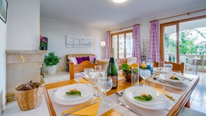 En matplats med ett bord dukat för två personer, en soffa och ett fönster med gardiner.