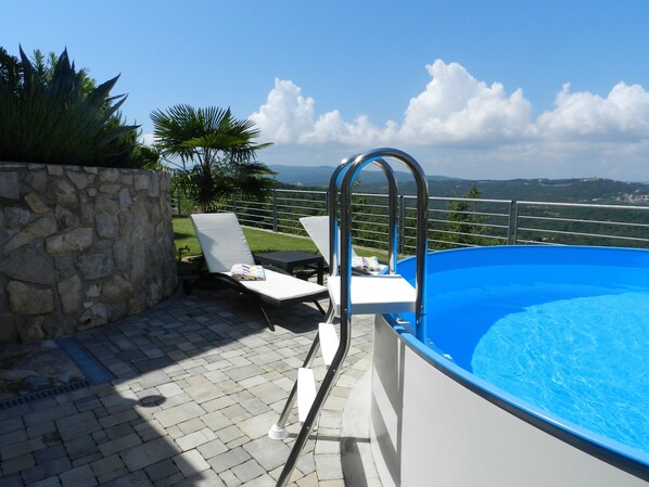 Relax by the serene pool surrounded by lush greenery and a tranquil atmosphere.