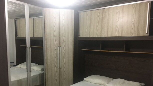 Une chambre à coucher avec un lit, une armoire et un miroir.