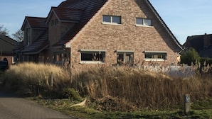 Une maison en briques avec un toit en pente et de nombreuses fenêtres.