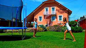 Une maison avec un balcon et un trampoline dans le jardin.