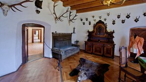 Une pièce dotée de parquets en bois, d’un lit, d’un lustre et de diverses têtes d’animaux empaillées accrochées aux murs.