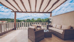 A covered outdoor seating area with wicker furniture and a view of the surrounding landscape. - Luxury Villa DELUXE with pool and sauna (Gabonjin)