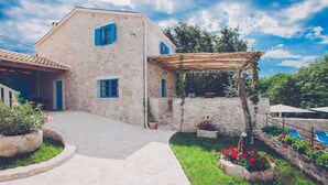 A stone building with blue shutters, a covered patio, and a swimming pool. - Luxury Villa DELUXE with pool and sauna (Gabonjin)