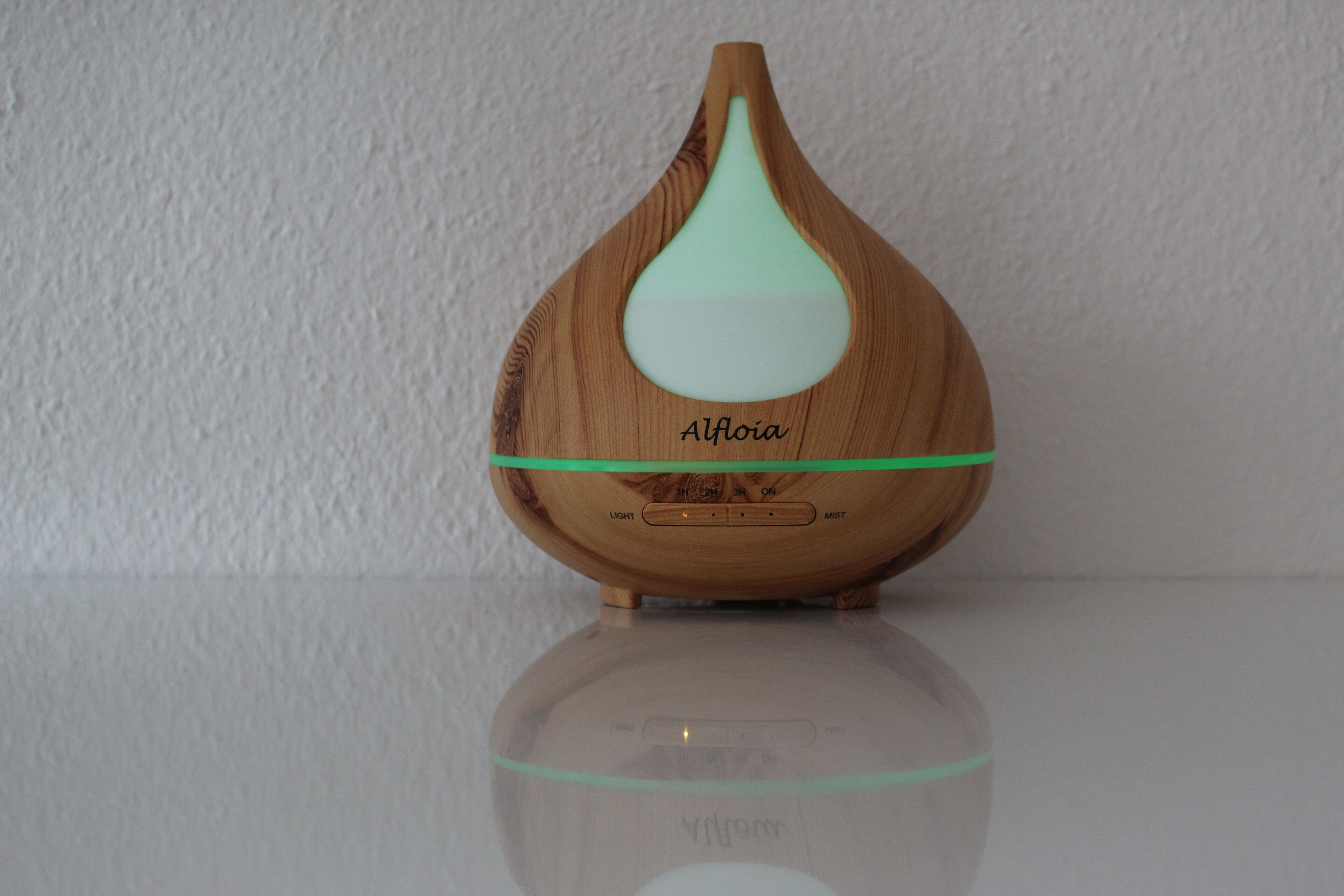 Un humidificador de madera AlFoia con indicador luminoso verde, un botón para la niebla y un interruptor de luz.