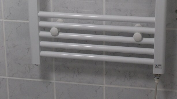 A white towel rack with multiple horizontal bars and round knobs, mounted on a tiled wall. - App with air conditioning, pool, garage for car, bike, skis, AktivCard bayer.Wald optional (St. Englmar)